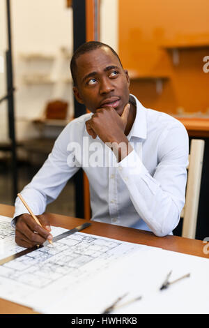 Pensive engineer looking aside while thinking over new idea Stock Photo