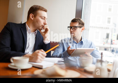 Businessmen analyzing sales at meeting Stock Photo