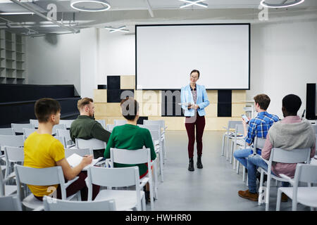 Young lecturer consulting her students attending course of study Stock Photo