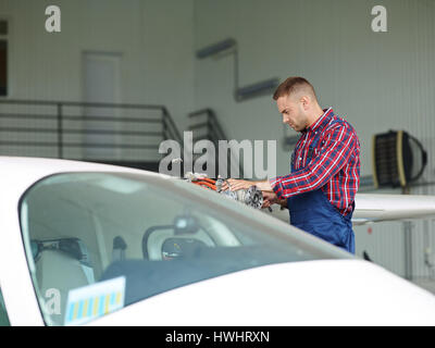 Young repairman in uniform working in hangar Stock Photo