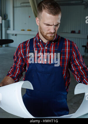 Professional repairman looking at sketch on paper Stock Photo
