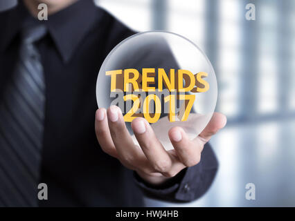 businessman hand holding Trends 2017 concept in crystal ball Stock Photo