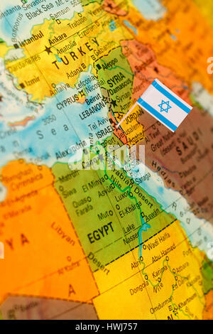 map with miniature flag of Israel .Selective focus on Israeli Flag.  Detail Globe Backlit lighting Stock Photo