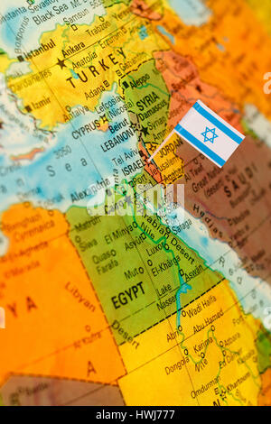 map with miniature flag of Israel .Selective focus on Israeli Flag.  Detail Globe Backlit lighting Stock Photo