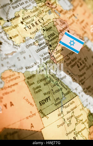 map with miniature flag of Israel .Selective focus on Israeli Flag.  Detail Globe Backlit lighting Stock Photo