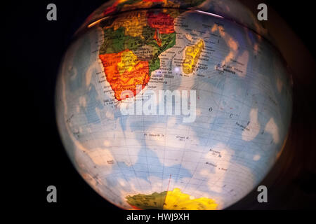 close up of old fashioned world globe a ball shaped map lit from within focusing on europe South Africa and Asia