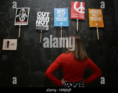 PABEST A museum staff member looking at placards gathered during an anti-Trident demonstration in London on February 27 2016, during a press view of the People Power: Fighting for Peace exhibition at the Imperial War Museum in London. Stock Photo