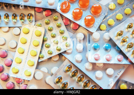 Pills of different colors lie on the surface in a sealed package Stock Photo
