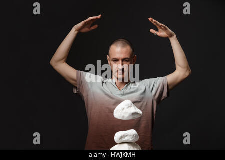 Telekinesis - man making stones levitating Stock Photo