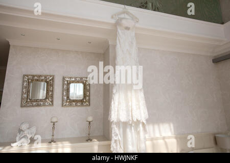 Wedding dress hanging in hotel room Stock Photo