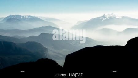 Spectacular view of mountain ranges silhouettes and fog in valleys. Stock Photo