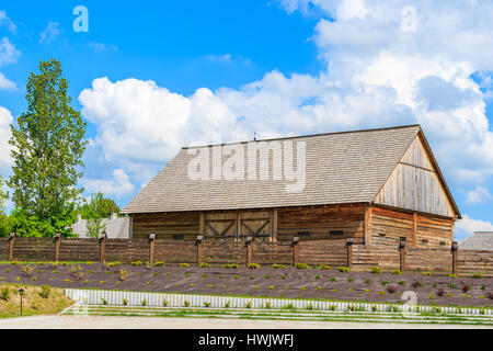 Old wooden barn in Tokarnia village on sunny spring day, Poland Stock Photo