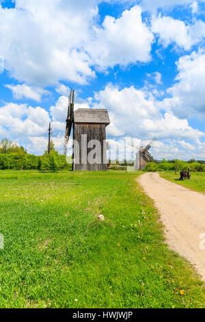 Old wooden windmill on green field in spring landscape of Tokarnia village, Poland Stock Photo