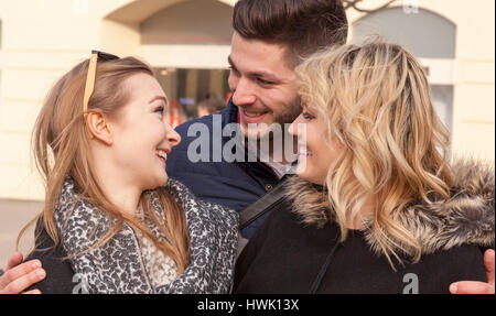 three young people happily smiling in city environment Stock Photo