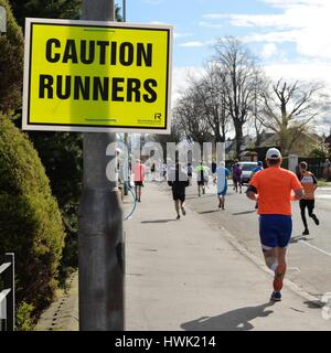 A sign cautioning traffic of runners on the public highway during the Alloa half marathon in Scotland, UK Stock Photo