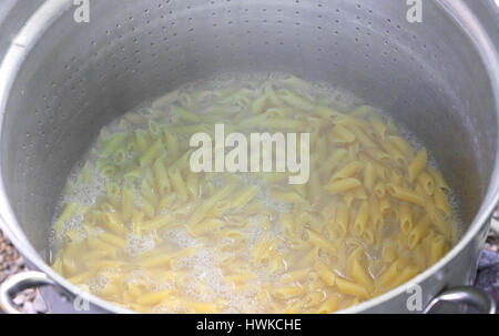 pasta called MEZZE PENNE in Italy cooked in the very hot water in huge pot of Italian restaurant Stock Photo