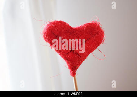 Red Heart on the stick made from thread on white background Stock Photo