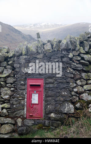 Old red, wall mounted Royal Mail letter box beside a country road in Cumbria Stock Photo