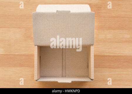 Open cardboard box on wooden background. Top view, unboxing concept and template Stock Photo
