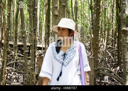 Traveler thai woman walking on wooden bridge in Mangrove forest or Intertidal forest for visit Golden Mangrove Field thai name Tung Prong Thong Forest Stock Photo