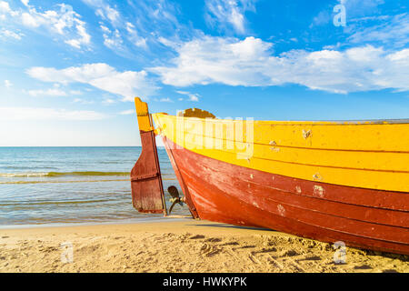 Colorful fishing boat on sandy Debki beach during sunny summer day, Baltic Sea, Poland Stock Photo