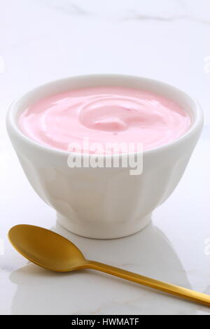 Delicious french custard-style yogurt with all the fruit mixed inside during the process. On vintage Italian carrara marble retro styling. Stock Photo