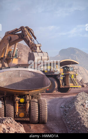 Loading of copper ore on very big dump-body truck Stock Photo