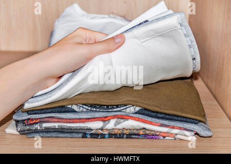 Woman pointing at clothes in closet Stock Photo