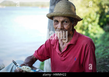 Cayo Granma, Santiago De Cuba. Cuba - January 11, 2016: old Cuban man who has caught crabs and displays the day's catch. He wears the straw hat as pro Stock Photo