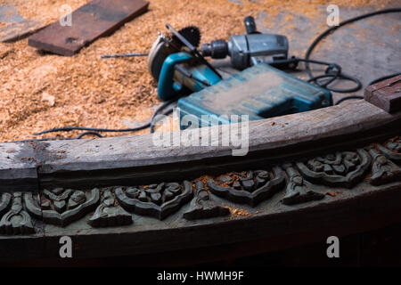 Woodworking tools and wood chips behind carved wooden sculpture at the Sanctuary of Truth in Pattaya, Thailand Stock Photo