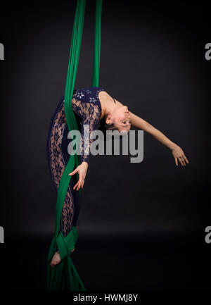 woman's aerial acrobatics in the paintings - dark background. Studio photography of circus performers Stock Photo