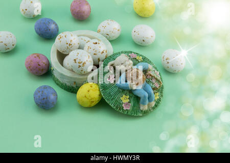Easter egg background - bunny sleeping in meadow with speckled eggs Stock Photo