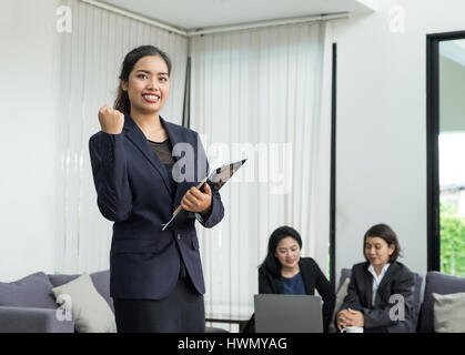 Businesswoman leader arm up for celebrating success with coworkers in office,triumph concept. Stock Photo