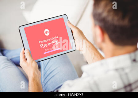 Composite image of text with wi-fi symbol against rear view of man using digital tablet Stock Photo