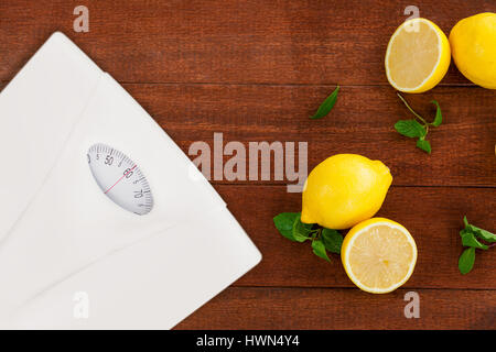 weighting scale against lemons and mint leaves on table Stock Photo