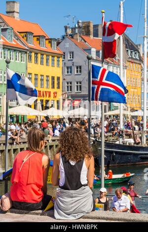 Denmark, Zealand, Copenhagen, Nyhavn district (new harbor), 18th century houses, restaurant terraces and canal side bar Stock Photo