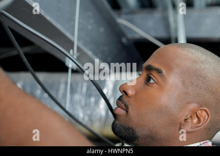 Checking under a ceiling hatch Stock Photo