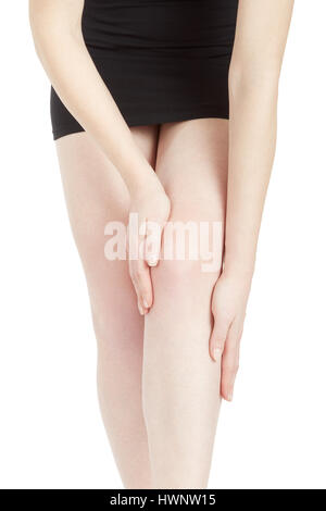 Young woman with black dress touching her tired leg isolated on white, clipping path Stock Photo
