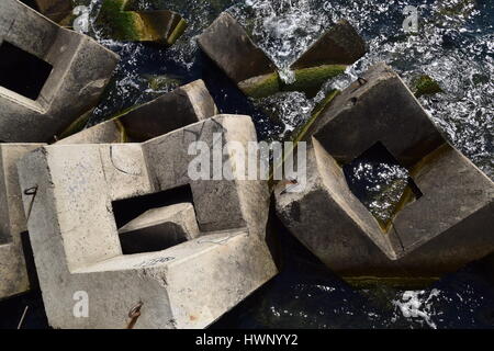 Breakwater blocks in the port. Breakwater of the rectangular stone figures. Stock Photo