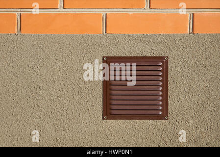 Steel brown ventilation grille in the wall outdoors Stock Photo