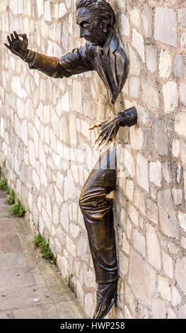 Le Passe-Muraille also known as Walker-Through-Walls sculpture located in a rue Norvins car park in Montmartre Paris France. Stock Photo