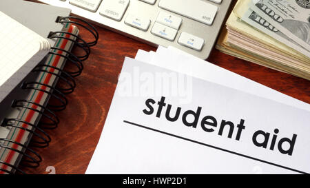 Document with title student aid and notebooks on a table. Stock Photo
