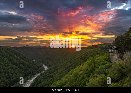The sun's rays leave behind an explosion of colors as the storm clouds break over the New River Gorge from Beauty Mountain. Stock Photo