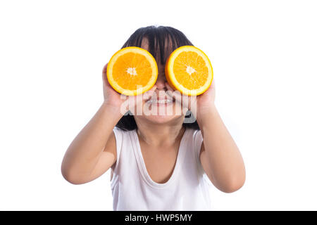 Happy Asian Chinese little girl using orange as glasses in isolated white background. Stock Photo