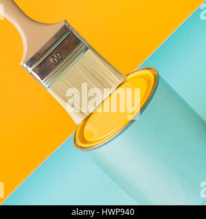 minimal image freshly painted yellow background and can with brush on blue table Stock Photo