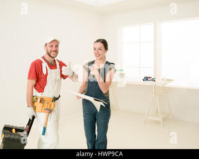 woman client and contractor talking, laughing at renovation site, apartment Stock Photo