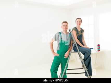 man and woman couple  ready to decorate home. bright white interior. repair, building, renovation and people concept Stock Photo