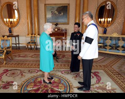 Queen Elizabeth II (left) is presented with Letters of Credence by the Ambassador from the Kingdom of Thailand, Mr. Pisanu Suvanajata (right), accompanied by his wife, Mrs. Thipayasuda Suvanajata (centre), during a private audience with Her Majesty at Buckingham Palace, London. Stock Photo