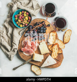 Variety of snacks and red wine in glasses, grey background Stock Photo