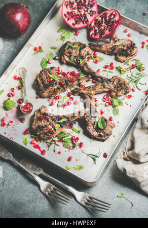 Grilled lamb ribs with pomegranate seeds, mint and rosemary Stock Photo